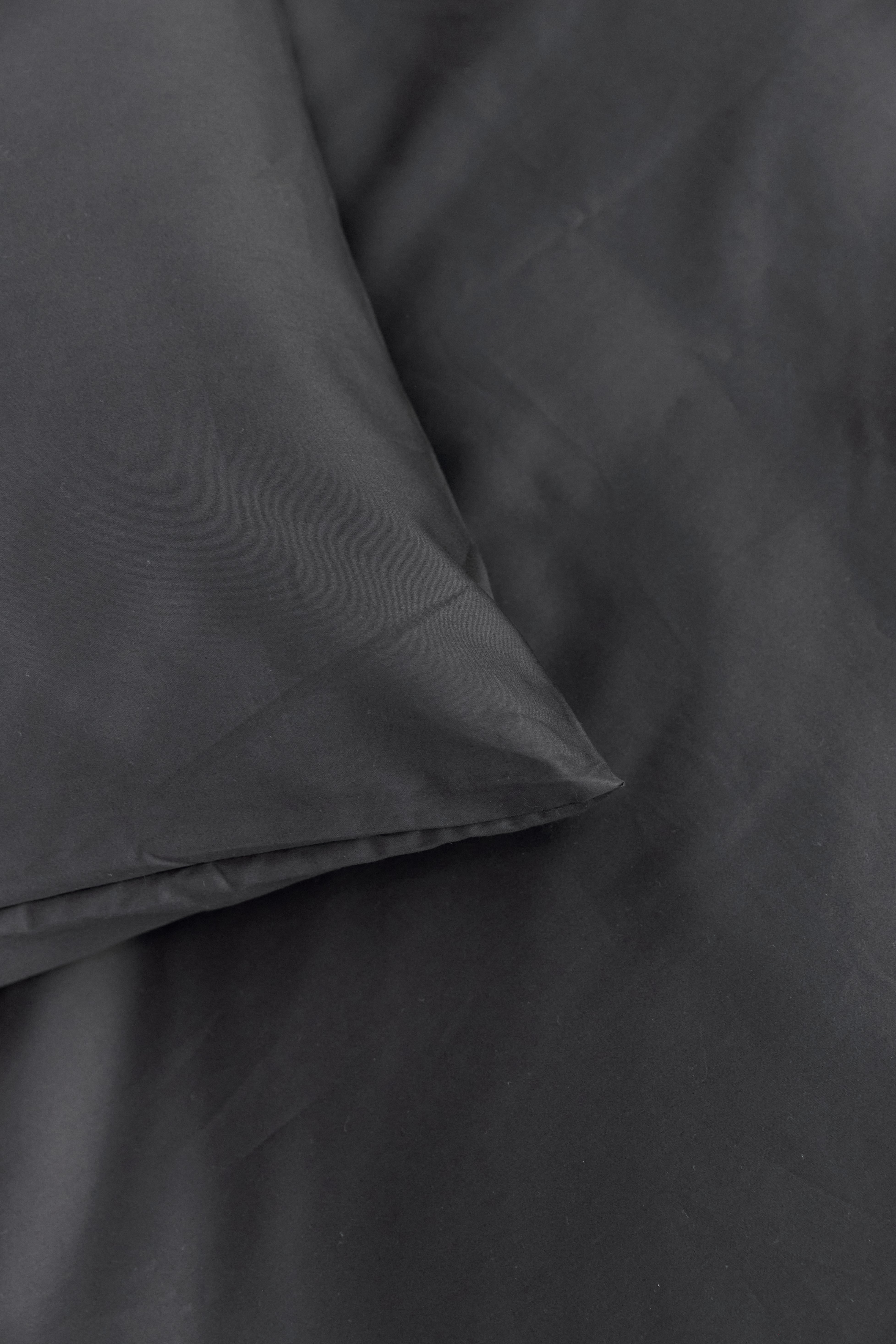 פינה של כרית עם מצעי כותנה בצבע אפור פחם