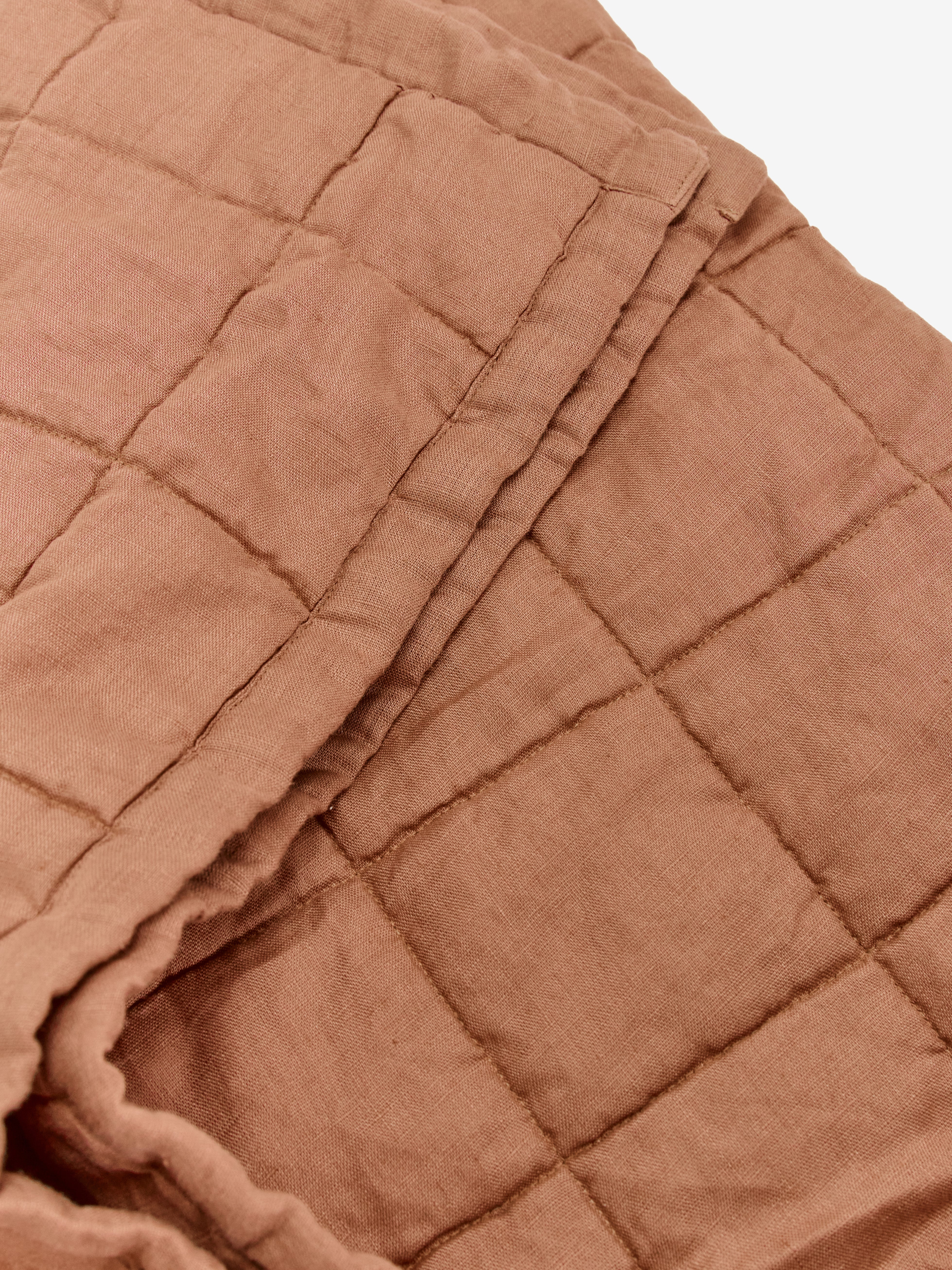 תקריב של שמחת קווילט מפשתן בצבע מוקה מקופלת