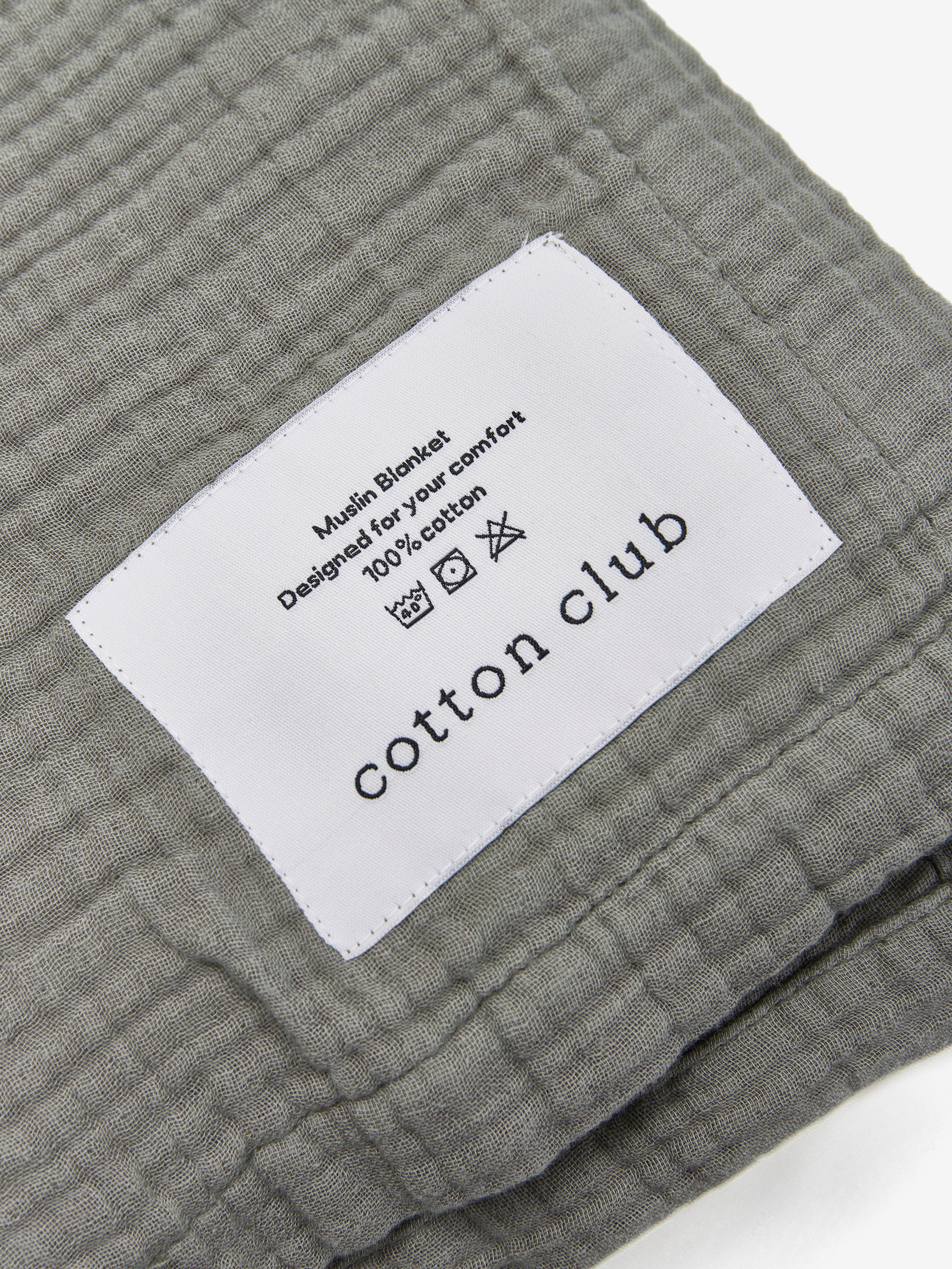 טיקט לוגו תפור על שמיכת מוסלין בצבע ירוק מרווה