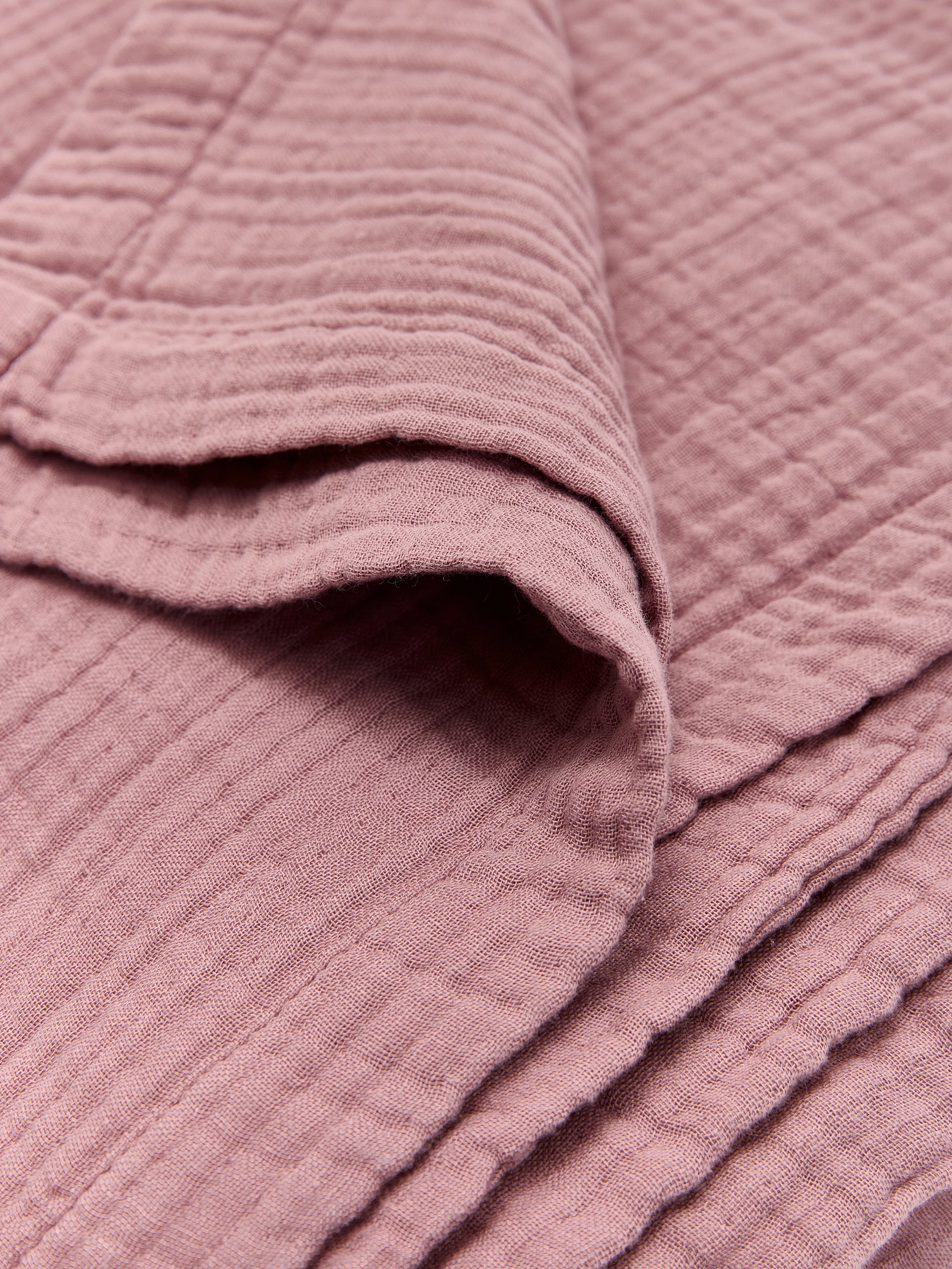 תקריב בד שמיכת מוסלין בצבע ורוד עתיק