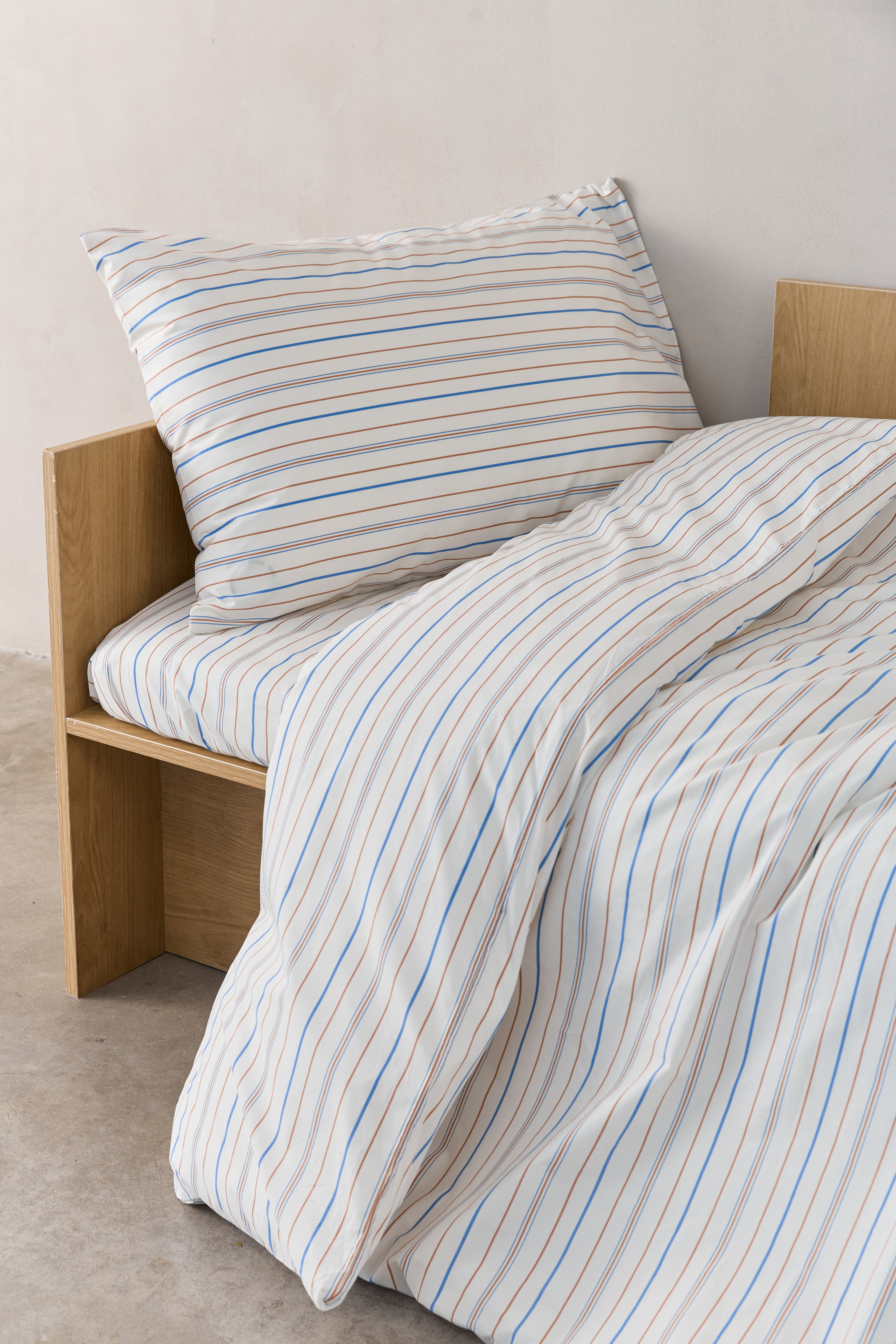 מיטת ילדים עם סט מצעי פרקל בצבע קרם עם פסים חומים וכחולים