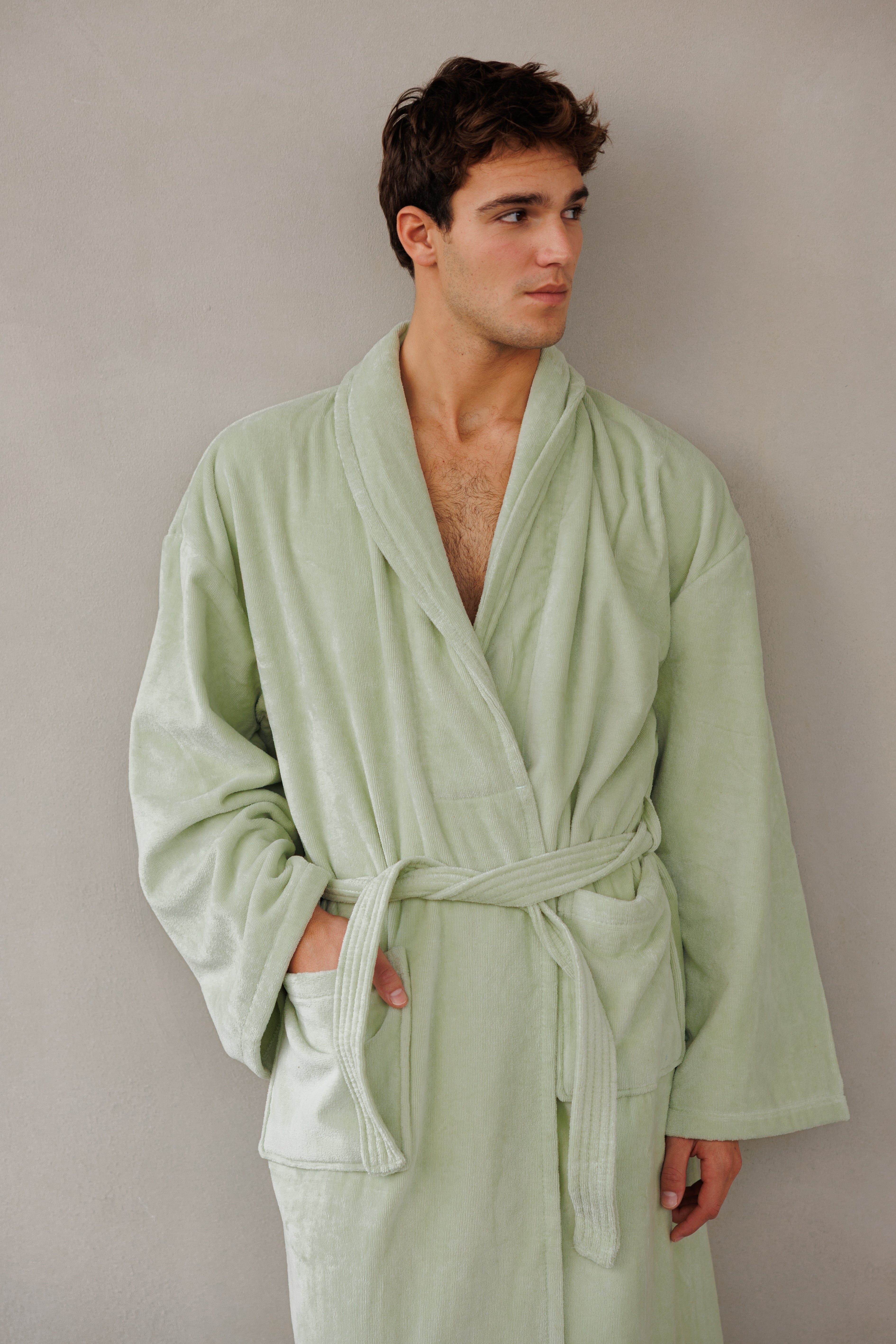 תקריב דוגמן עומד כנגד קיר ומביט הצידה עם חלוק קלאסי בצבע ירוק ליים