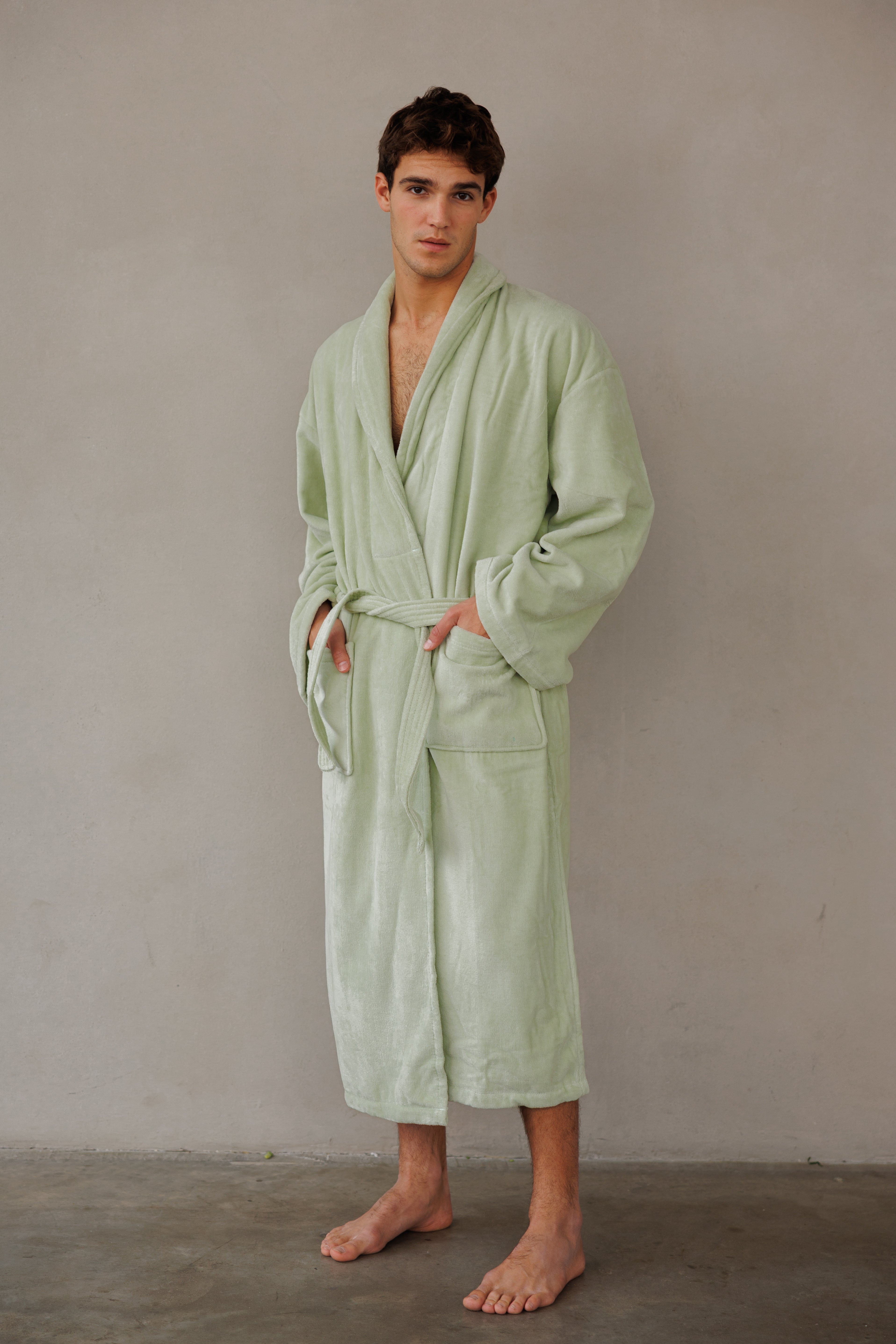 דוגמן עומד על הצד עם חלוק קלאסי בצבע ירוק ליים וידיים בכיסים