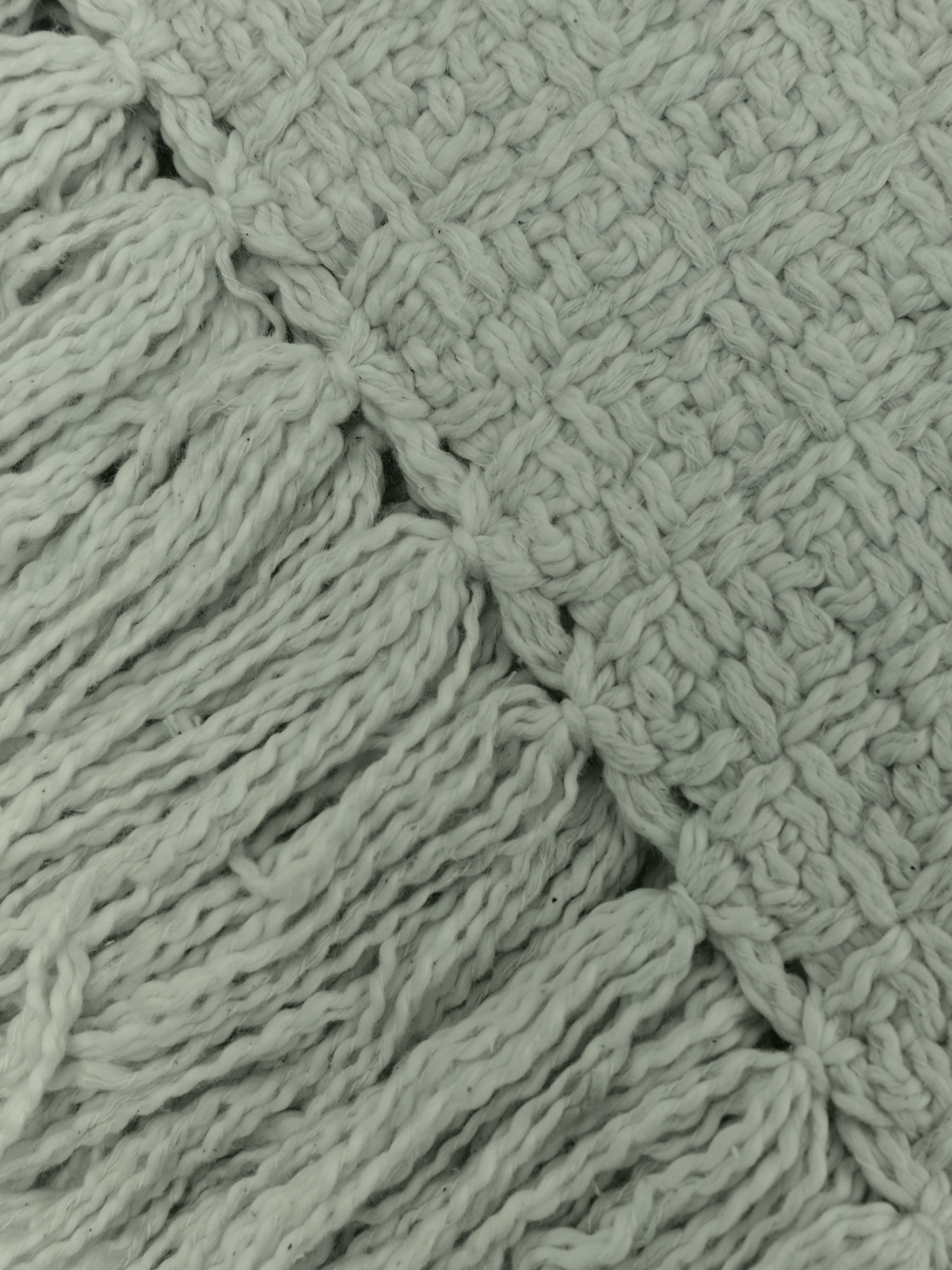 תקריב בד כותנה ארוג בצבע ירוק מרווה עם סיומת פרנזים