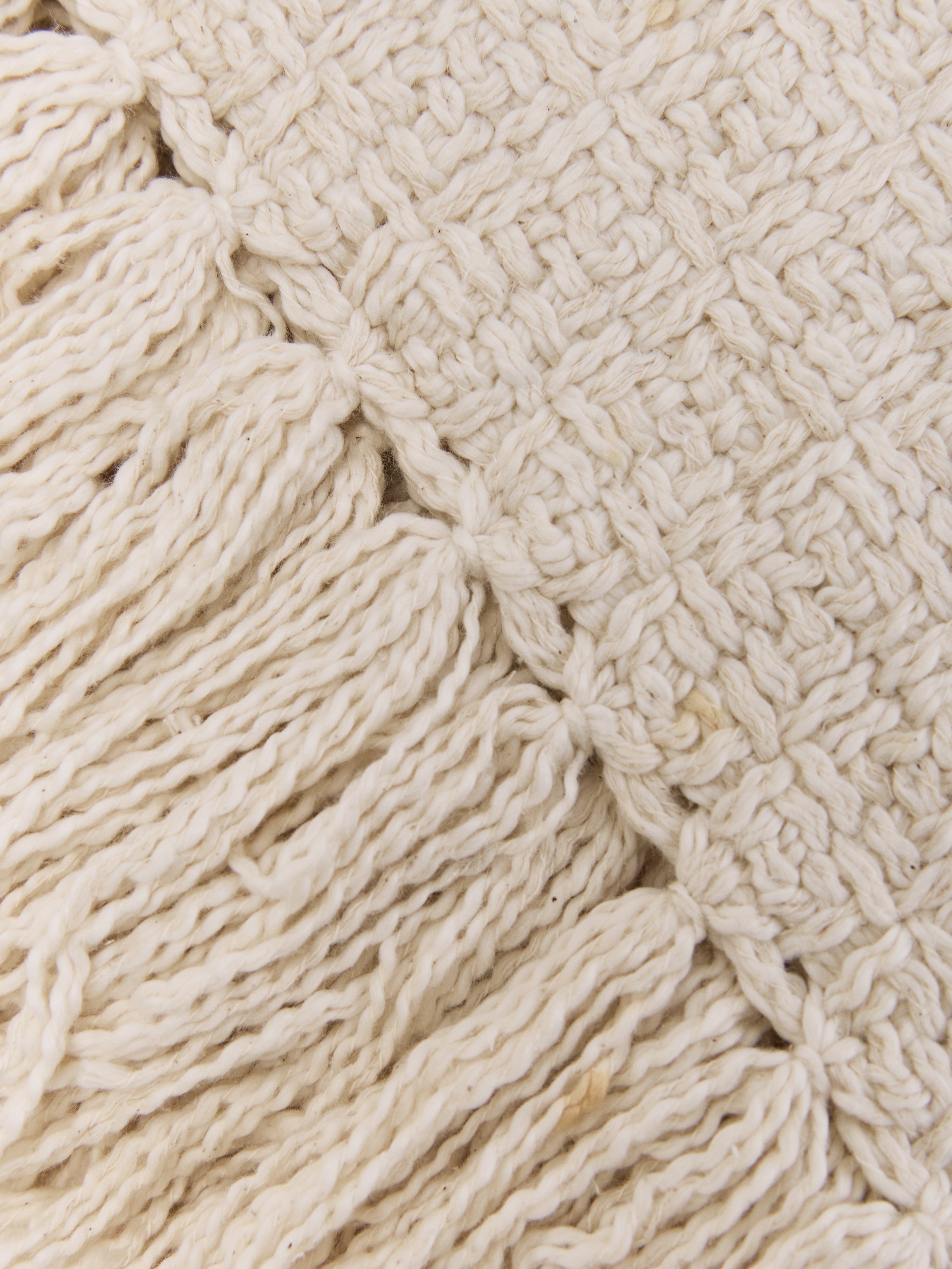 תקריב בד כותנה ארוג בצבע שמנת עם סיומת פרנזים