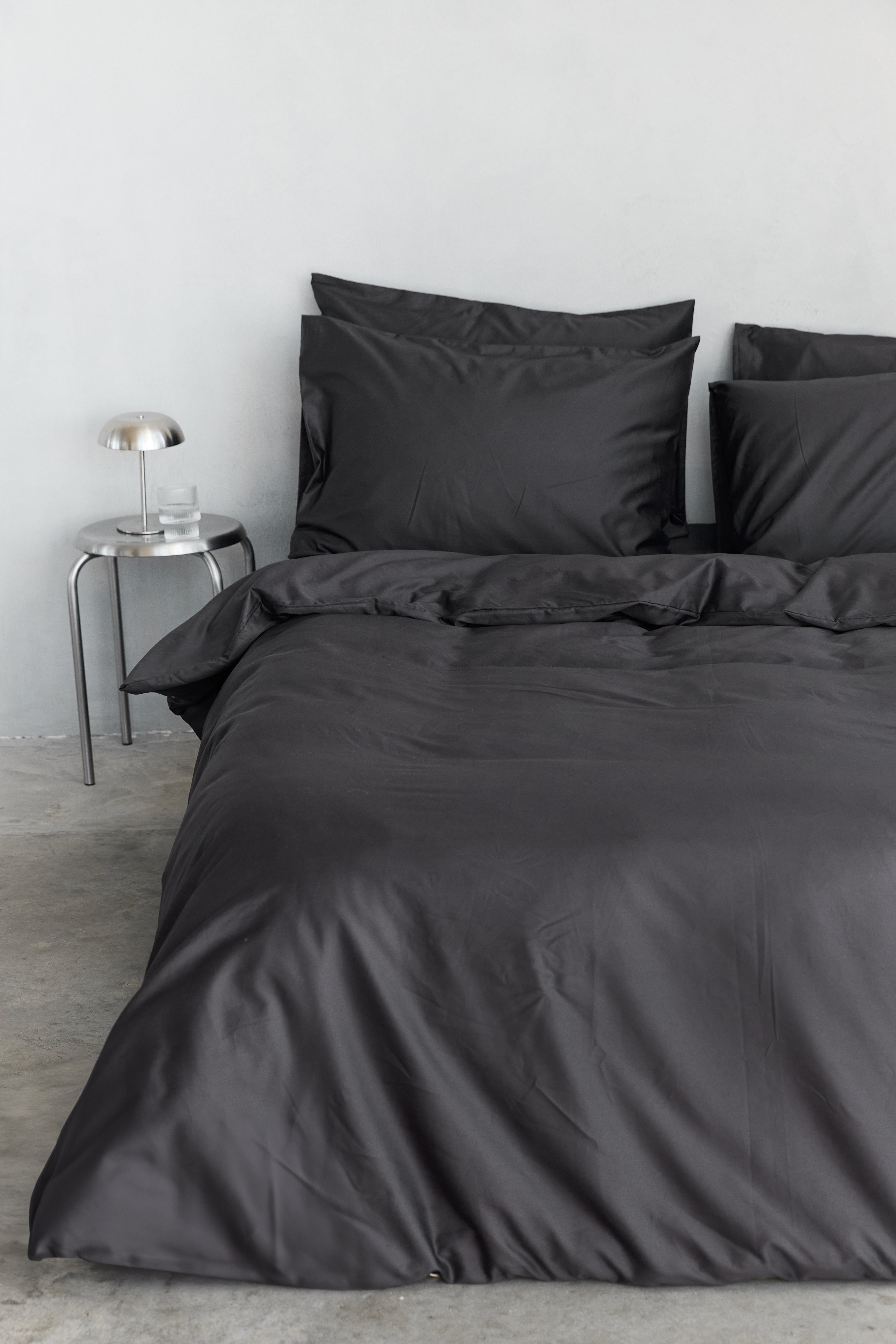 סט מצעי כותנה בצבע אפור פחם, על מיטה זוגית