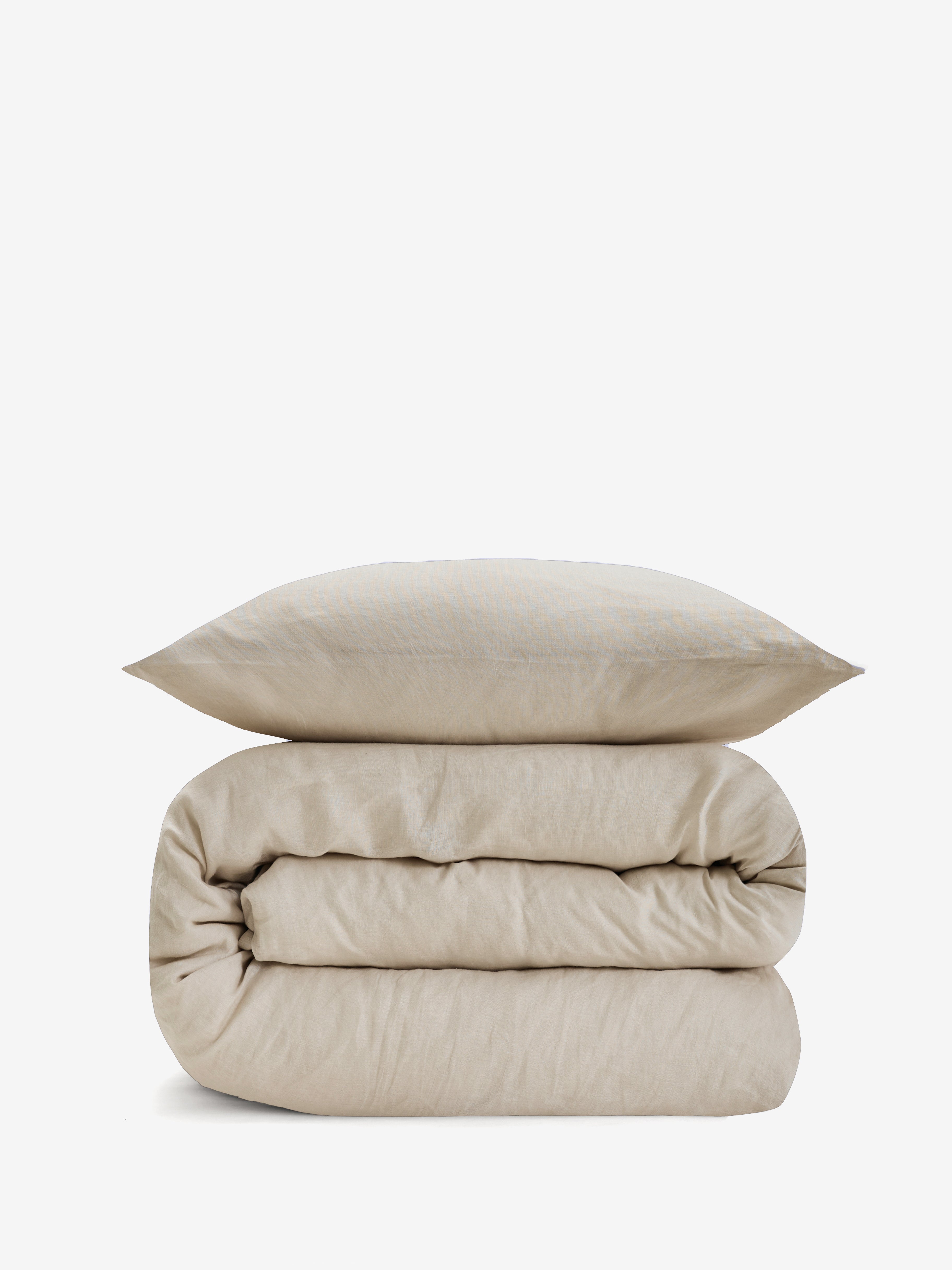 סט מצעי פשתן בצבע בז', שמיכה מגולגלת וכרית מעליה