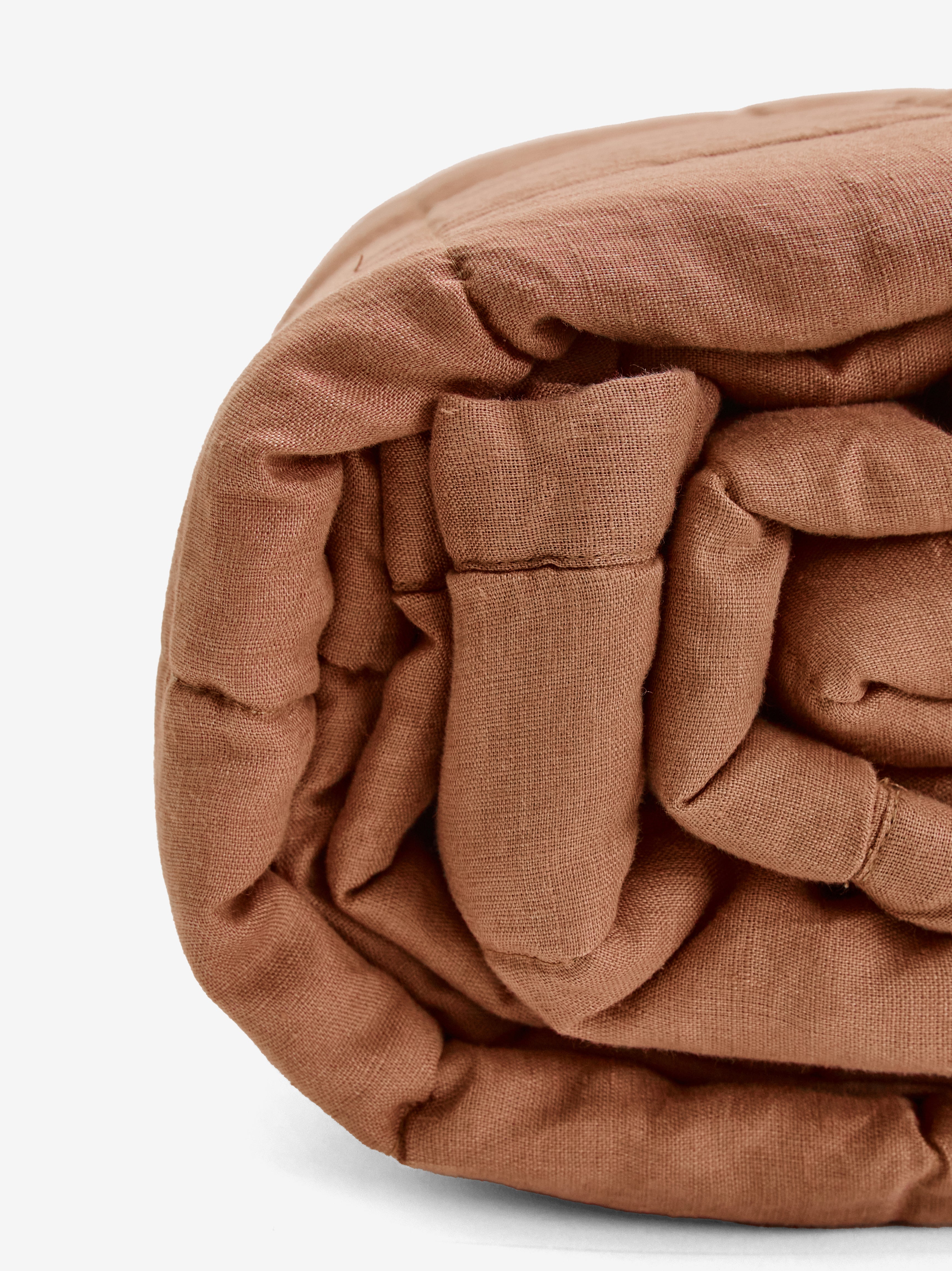 תקריב של שמיכת קווילט מפשתן בצבע מוקה