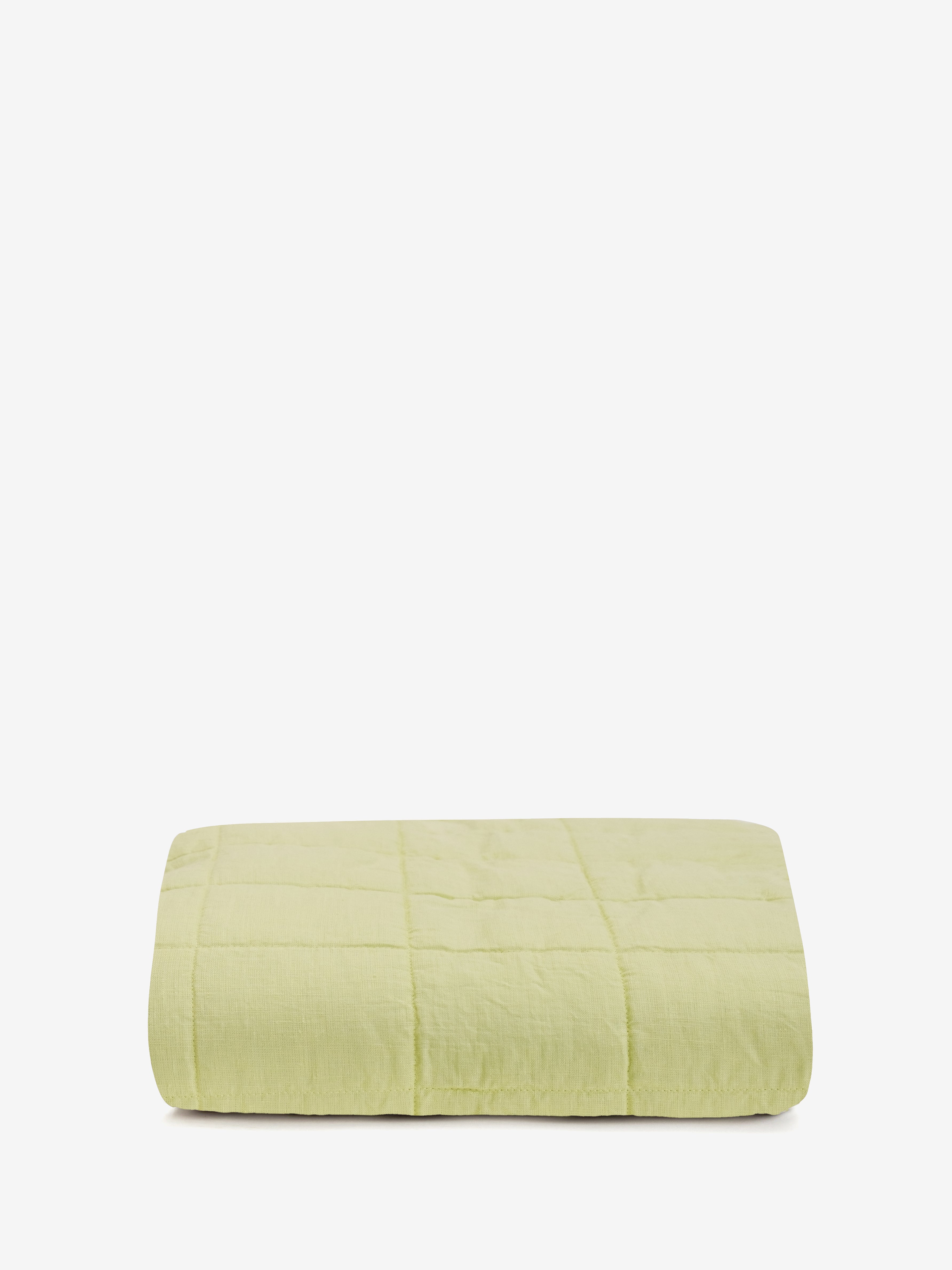  שמיכת קווילט מפשתן בצבע ליים מקופלת על רקע לבן