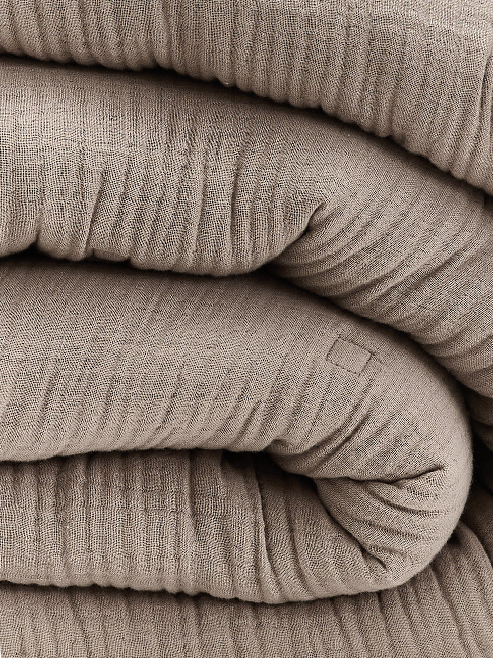 תקריב קפלים של שמיכת פוך מוסלין בצבע מוקה