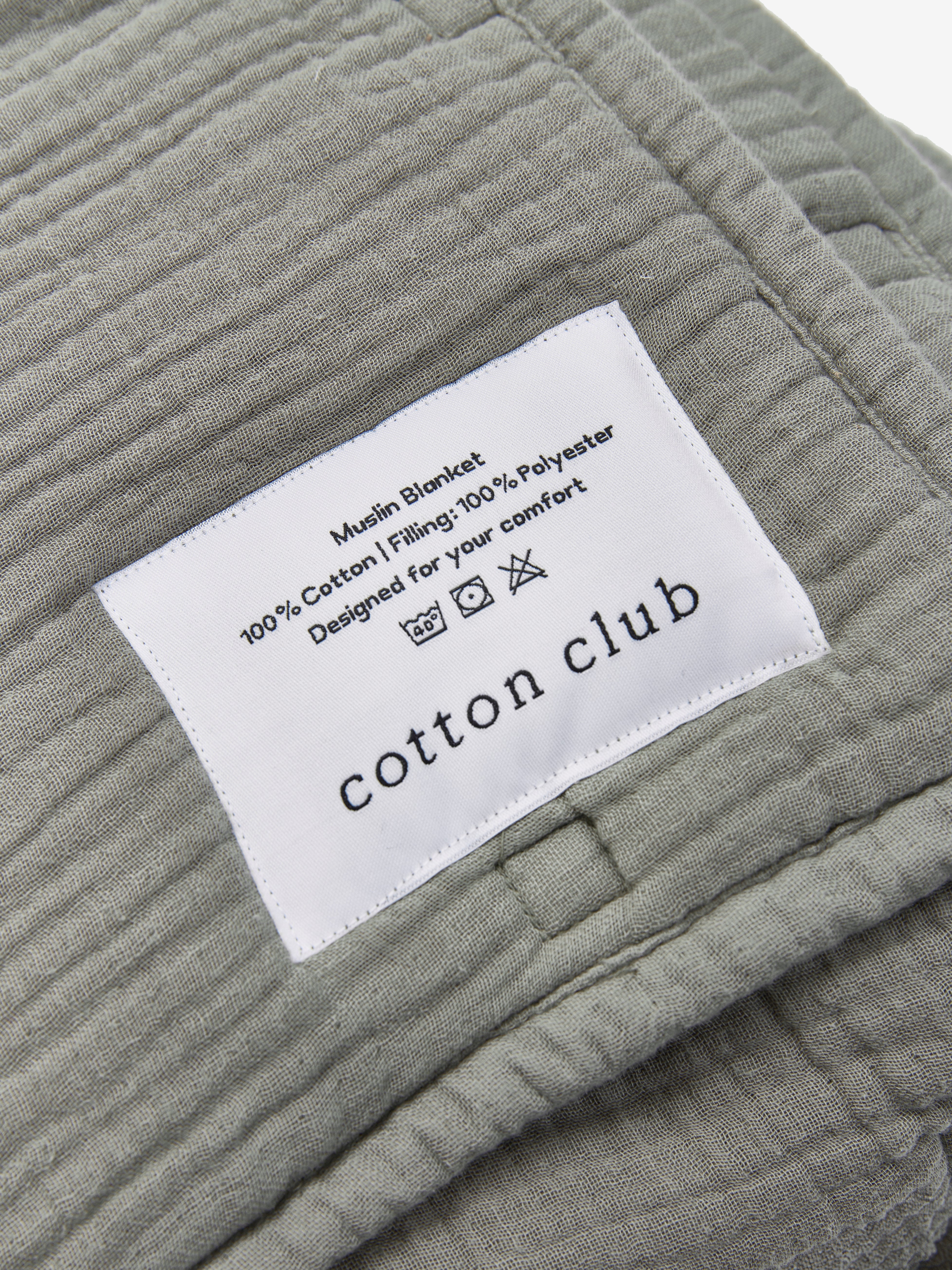 טיקט לוגו תפור על שמיכת פוך מוסלין בצבע ירוק מרווה