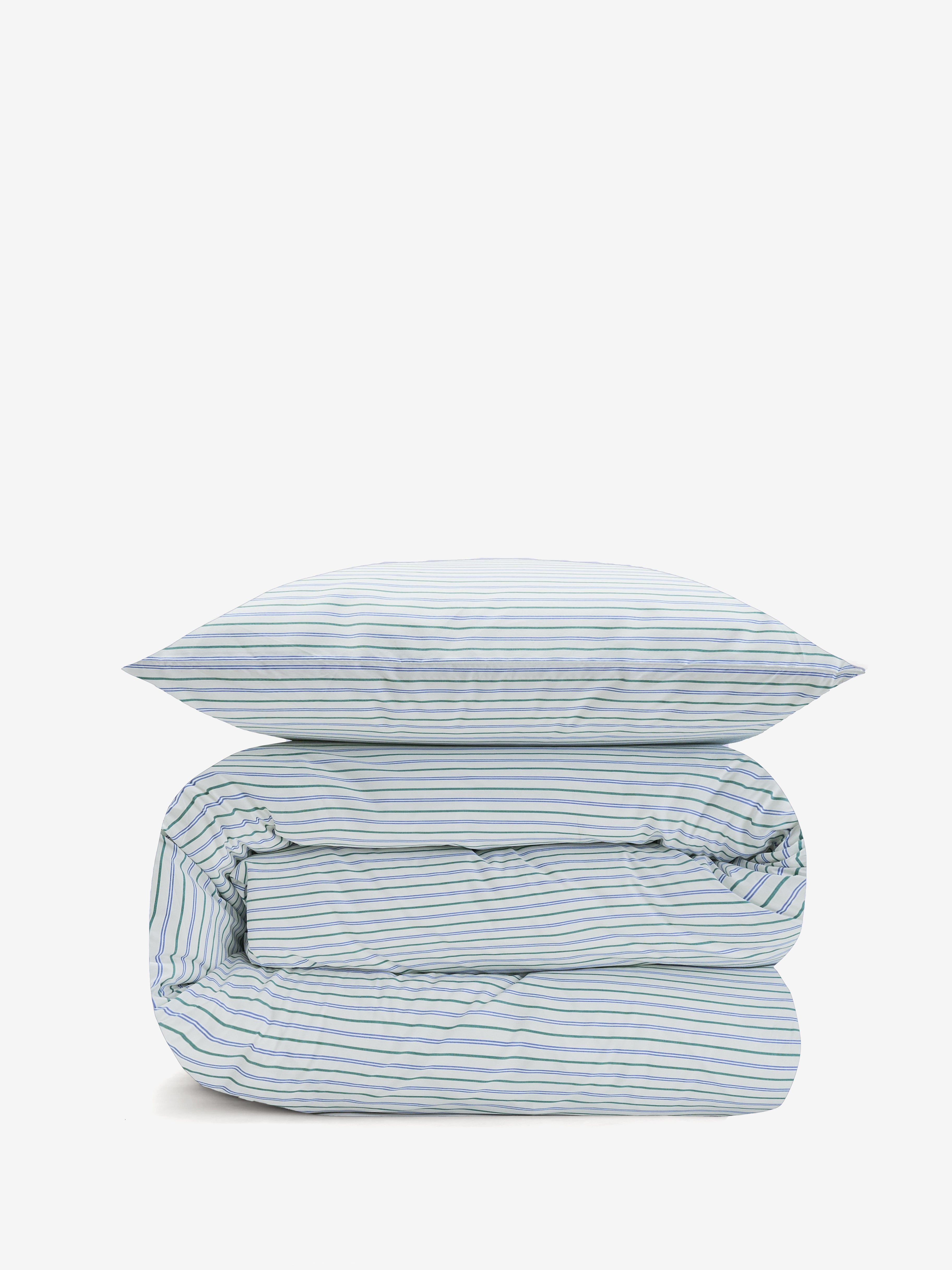 שמיכה מגולגלת ועליה כרית, עם סט מצעי פרקל לבנים עם פסים כחולים וירוקים