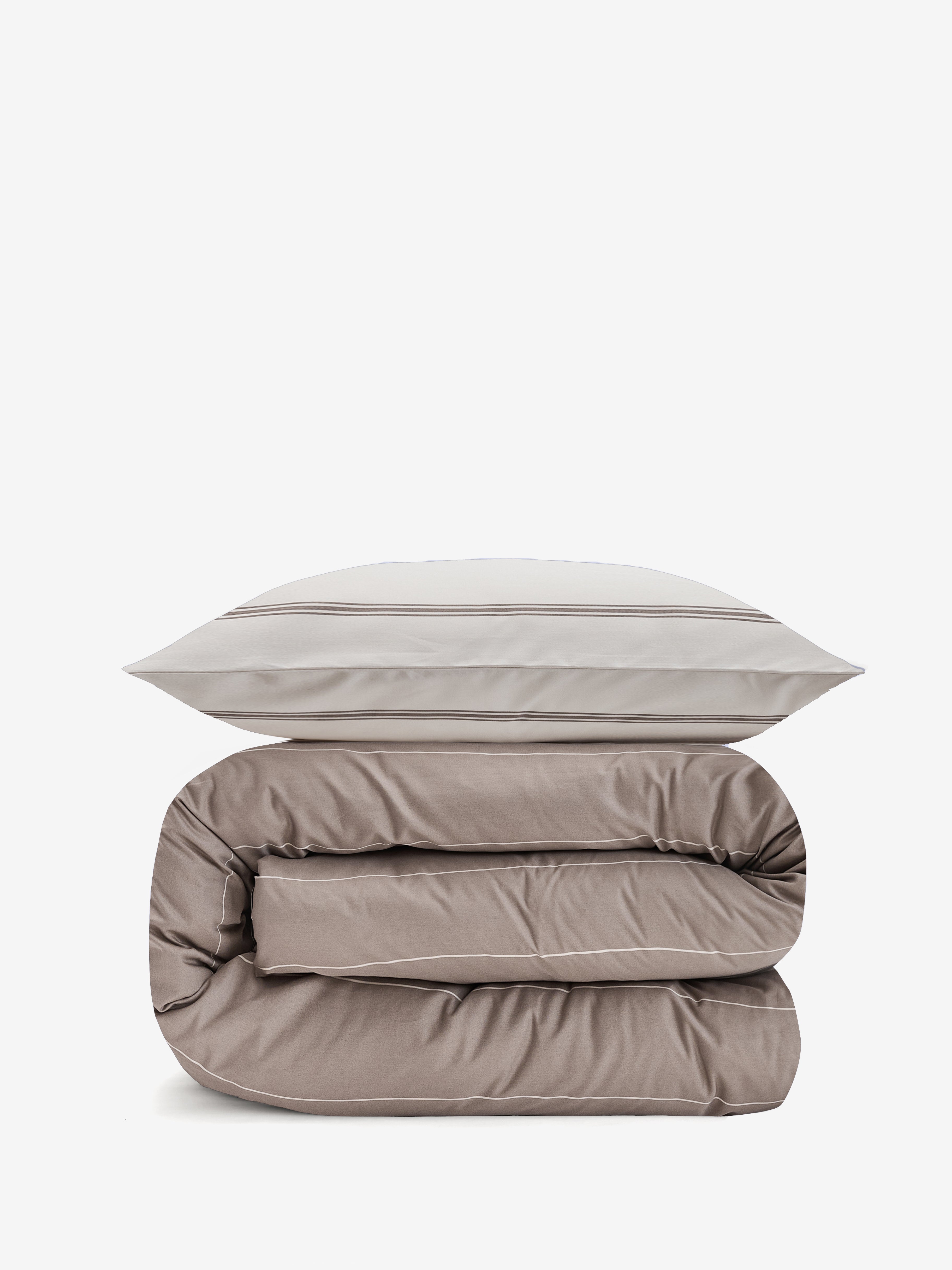 שמיכה מגולגלת וכרית עליה עם מצעי סאטן 500 דו"צ הכרית בצבע קרם עם פסים בצבע אבן והציפה בצבע אבן עם פסים בצבע קרם