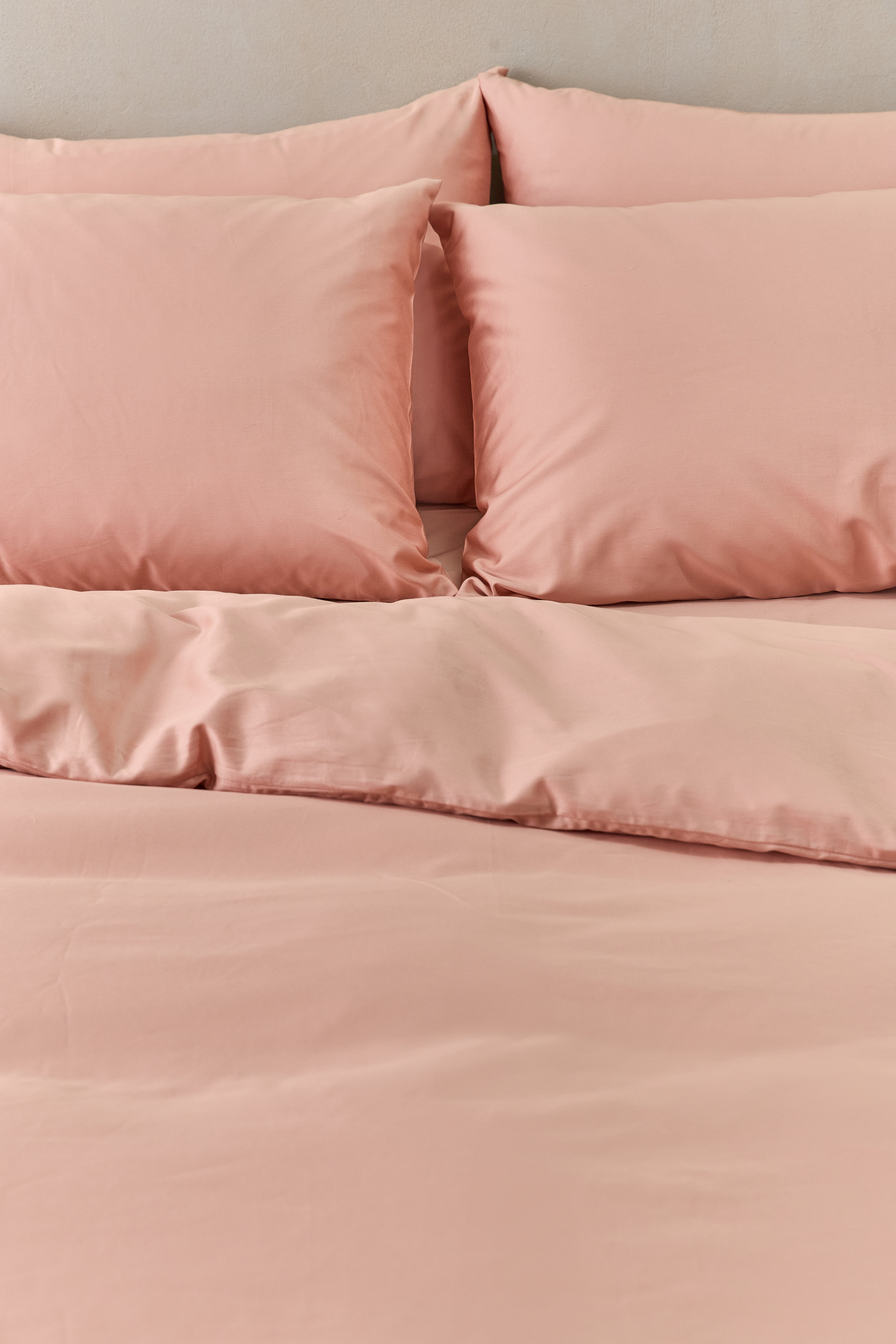 תקריב מיטה זוגית עם סט מצעי כותנה בצבע אפרסק