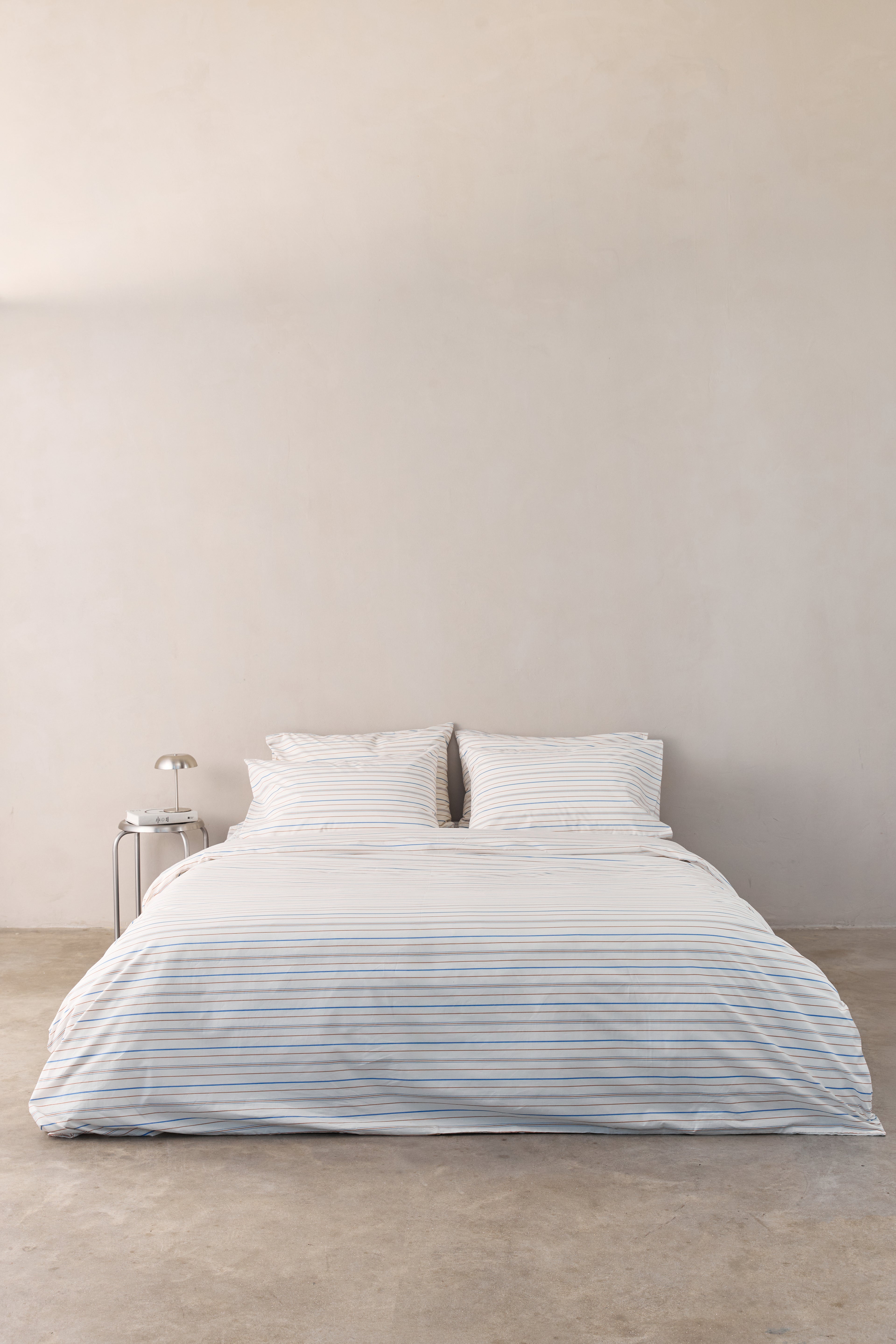 מיטה זוגית עם סט מצעי פרקל בצבע קרם עם פסים חומים וכחולים