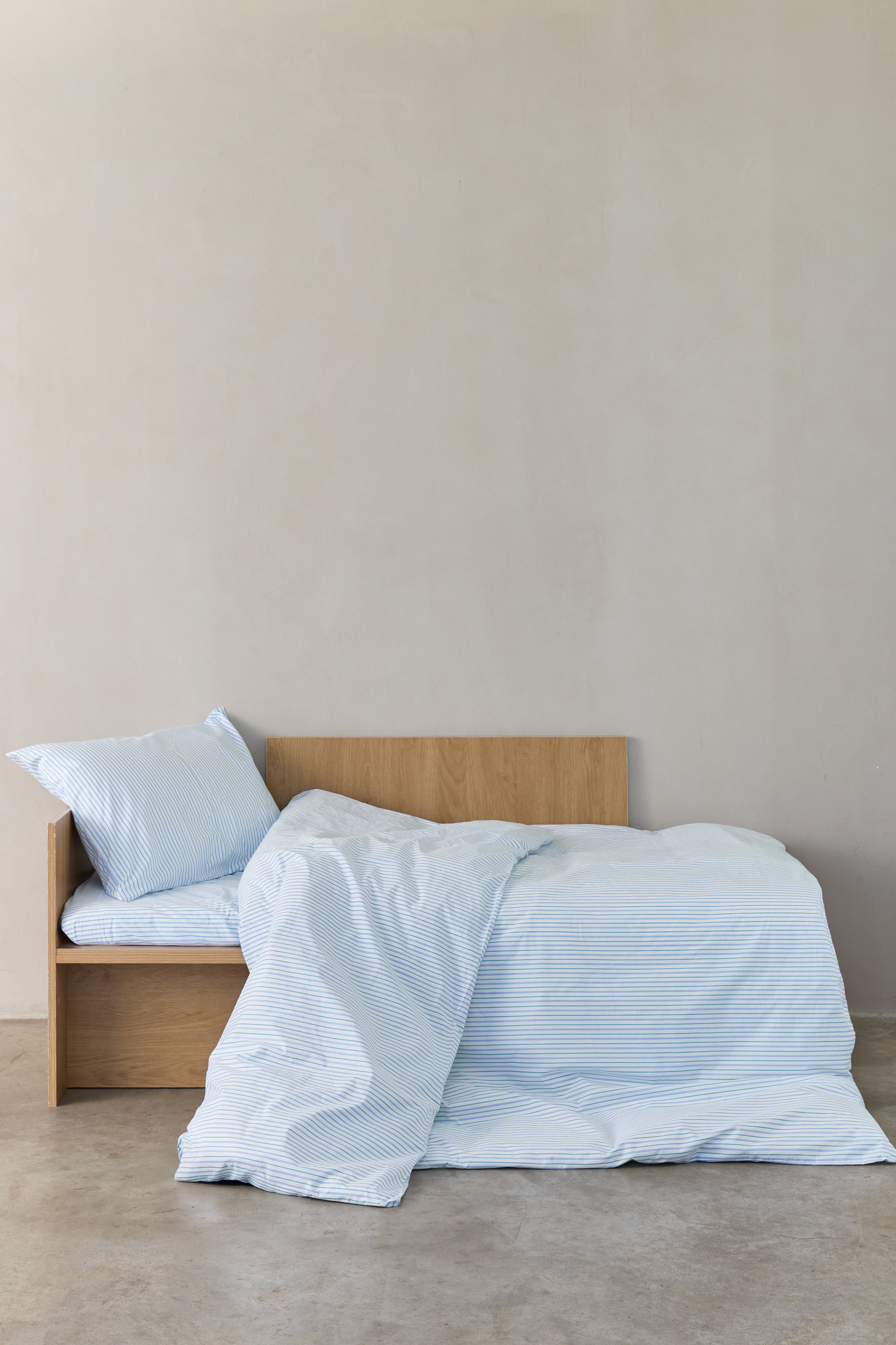 מיטת ילדים עם סט מצעי פרקל לבנים עם פסים כחולים וירוקים