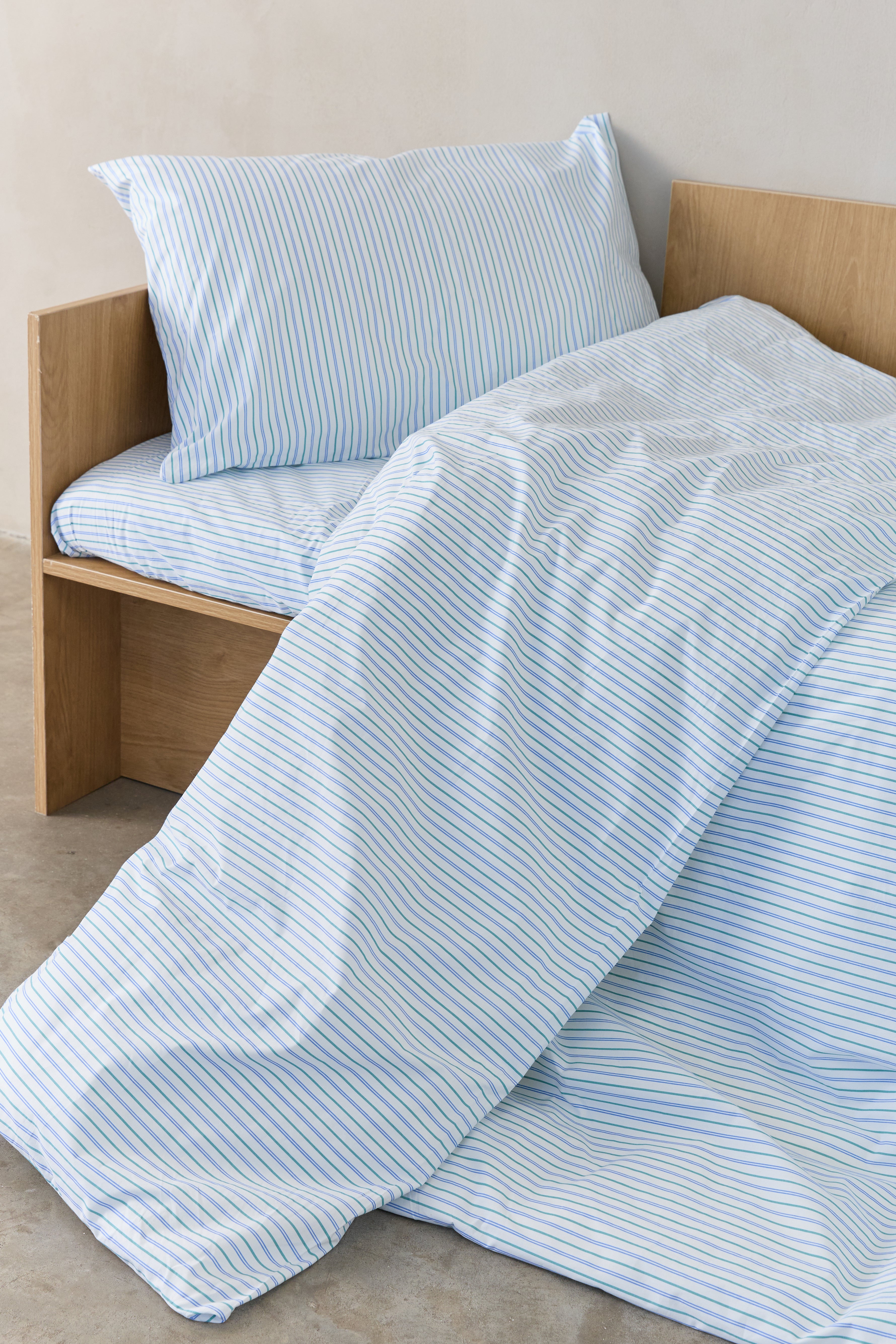 מיטת ילדים עם סט מצעי פרקל לבנים עם פסים כחולים וירוקים