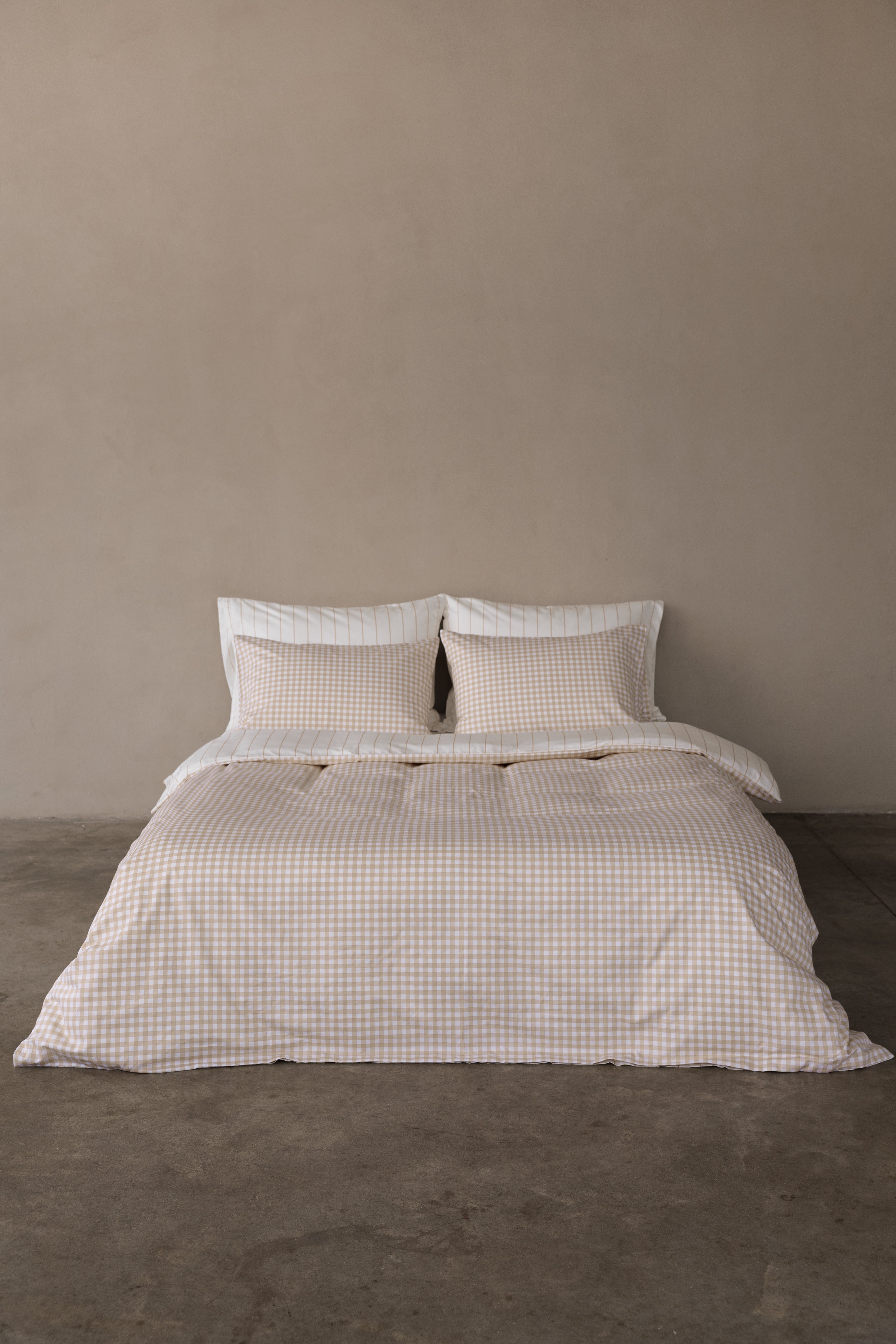  מיטה זוגית עם מצעי סאטן 500 כריות אחוריות לבנות עם פסים בז', כריות קדמיות משבצות בז', סדין לבן עם פסים בז' וציפה דו צדדית צד אחד משבצות צד אחד פסים